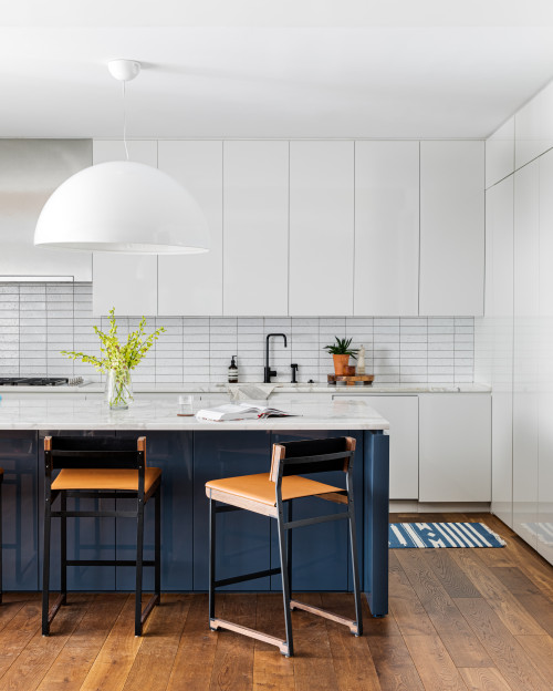 Blue Accents: Blue and White Cabinets with a White Backsplash and Marble Countertop