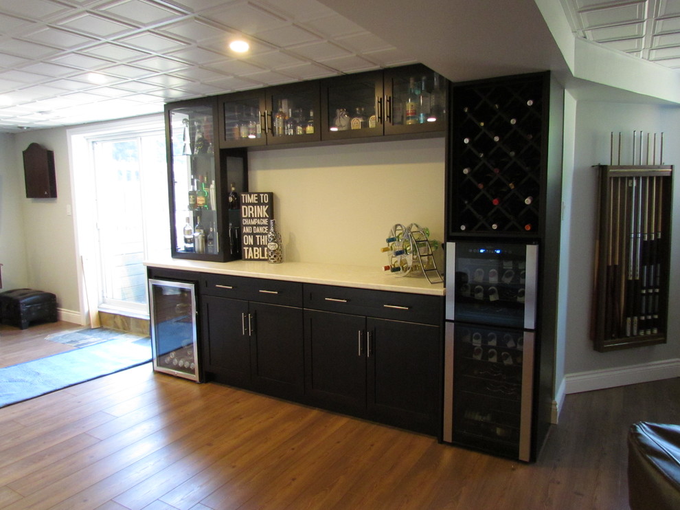 This is an example of a modern single-wall home bar in Toronto with dark wood cabinets and laminate benchtops.