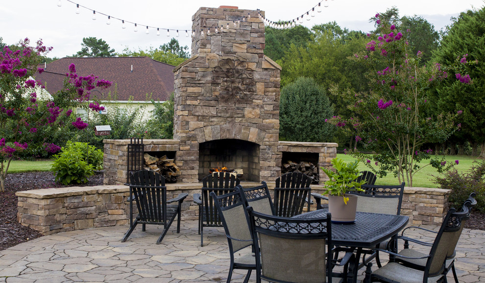 Photo of a mid-sized traditional backyard patio in Other with a fire feature and natural stone pavers.