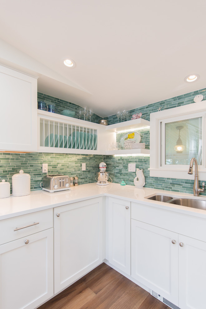 Inspiration for a small beach style u-shaped separate kitchen in Boston with an undermount sink, shaker cabinets, white cabinets, quartz benchtops, green splashback, subway tile splashback, stainless steel appliances, medium hardwood floors, no island and white benchtop.