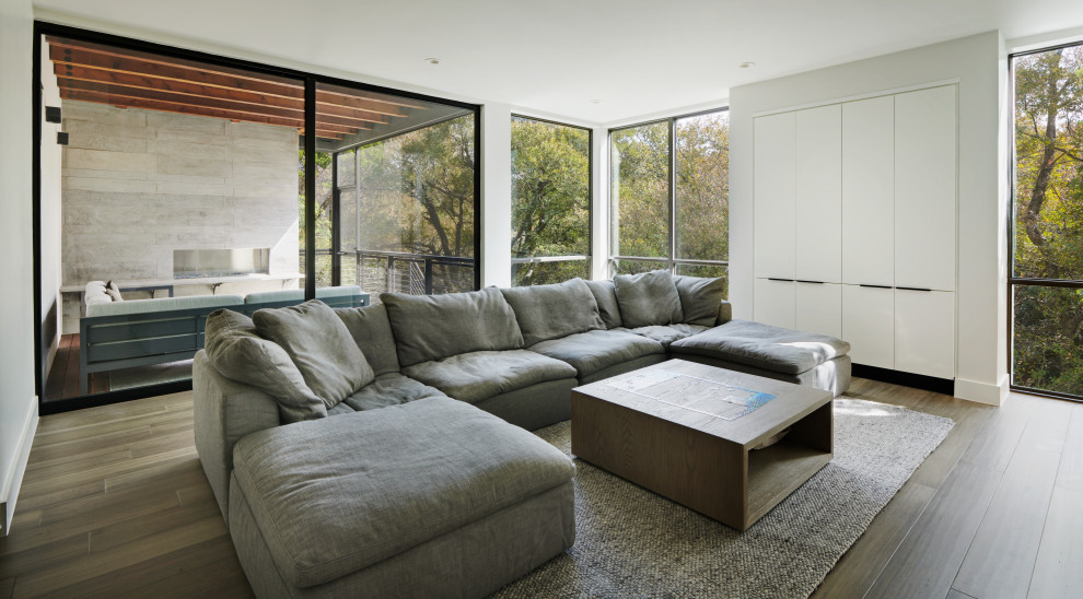 Ispirazione per un soggiorno minimalista di medie dimensioni e chiuso con angolo bar, pareti grigie, pavimento in bambù, TV a parete e pavimento grigio