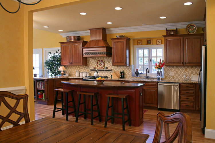 Inspiration for a large transitional u-shaped medium tone wood floor open concept kitchen remodel in Charlotte with an undermount sink, raised-panel cabinets, dark wood cabinets, granite countertops, ceramic backsplash, stainless steel appliances and an island