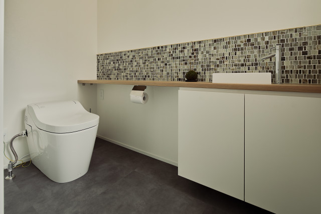 モザイクタイルとメラミンカウンターがシンプルなトイレルーム scandinavo-bagno-di-servizio