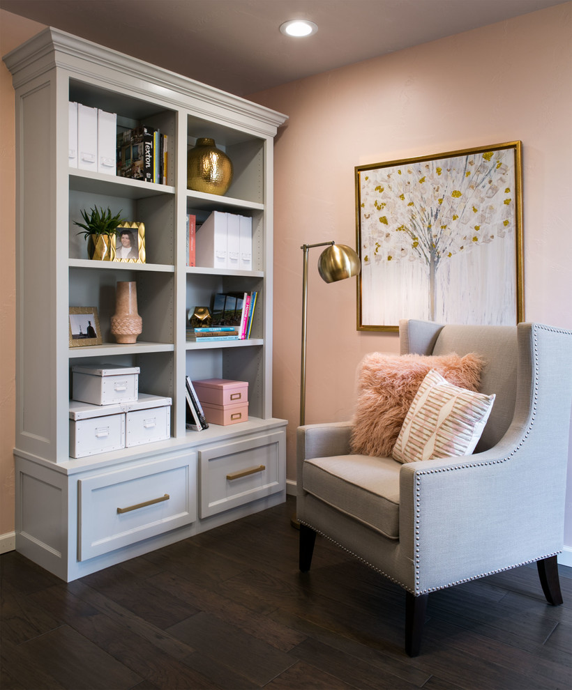 This is an example of a transitional home office in Oklahoma City with pink walls, dark hardwood floors, a built-in desk and brown floor.