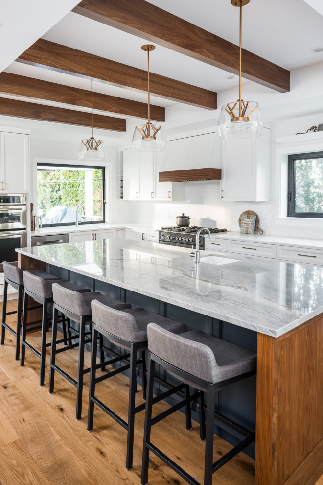 Inspiration for a large transitional galley kitchen in Vancouver with a drop-in sink, shaker cabinets, white cabinets, quartz benchtops, white splashback, ceramic splashback, stainless steel appliances, light hardwood floors, with island, beige floor, grey benchtop and exposed beam.