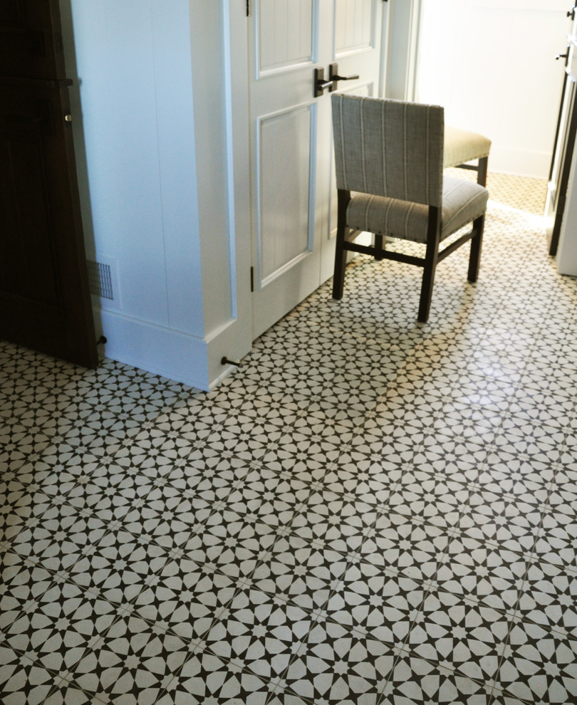 Example of a mid-sized transitional concrete floor and multicolored floor mudroom design in Milwaukee with white walls