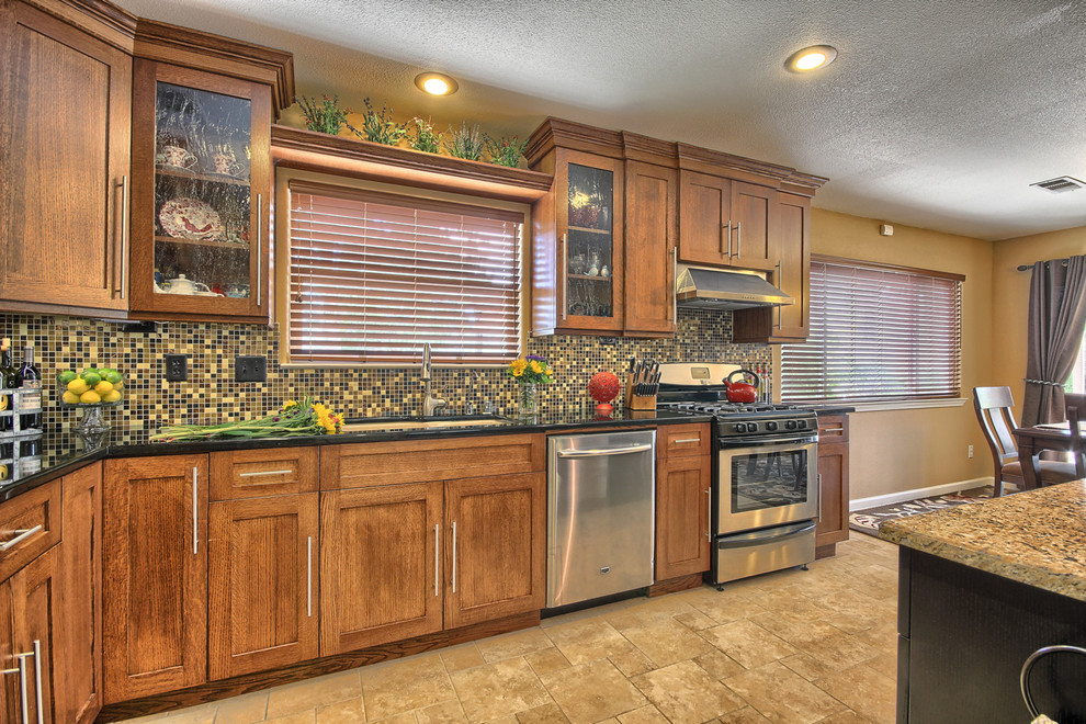 Example of a mid-sized transitional l-shaped porcelain tile eat-in kitchen design with an undermount sink, shaker cabinets, medium tone wood cabinets, granite countertops, multicolored backsplash, glass sheet backsplash, stainless steel appliances and an island