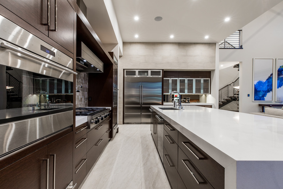 Photo of an expansive contemporary l-shaped open plan kitchen in Las Vegas with an undermount sink, flat-panel cabinets, dark wood cabinets, stainless steel appliances, with island, quartzite benchtops, grey splashback, stone tile splashback, marble floors and grey floor.