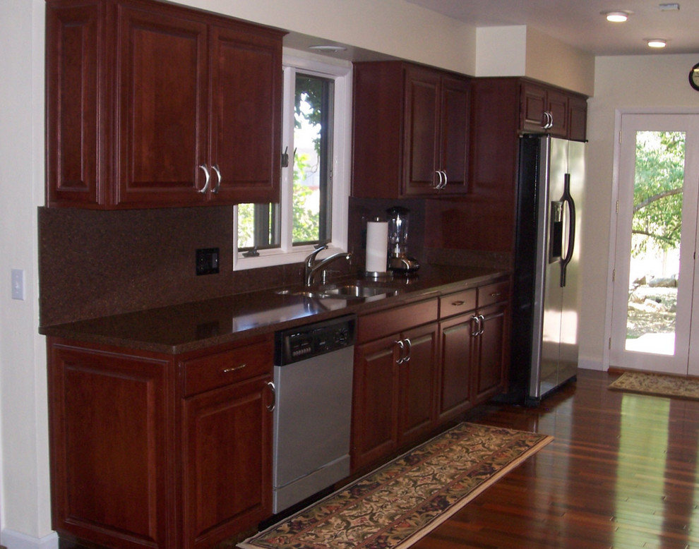 Inspiration for a large timeless single-wall kitchen remodel with dark wood cabinets, stainless steel appliances and an island