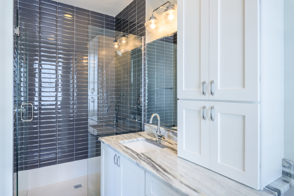 This is an example of a mid-sized transitional 3/4 bathroom in Orlando with shaker cabinets, white cabinets, a curbless shower, gray tile, subway tile, ceramic floors, an undermount sink, marble benchtops, a hinged shower door and multi-coloured benchtops.