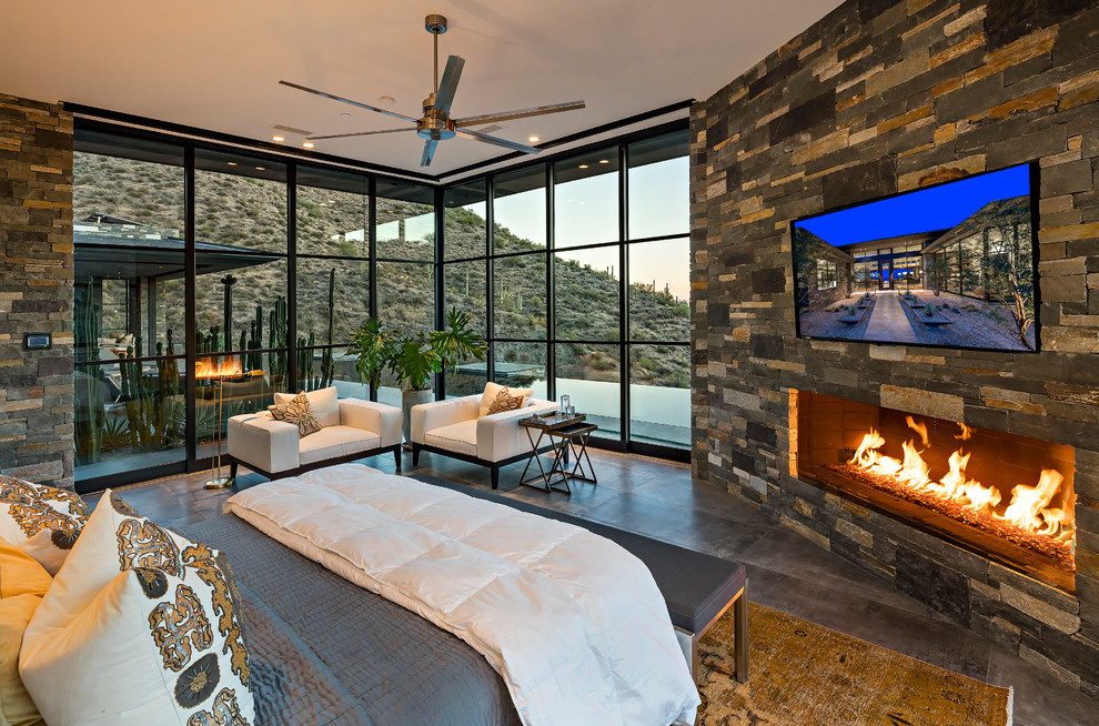 Photo of a large modern master bedroom in Phoenix with multi-coloured walls, porcelain floors, a ribbon fireplace and a stone fireplace surround.