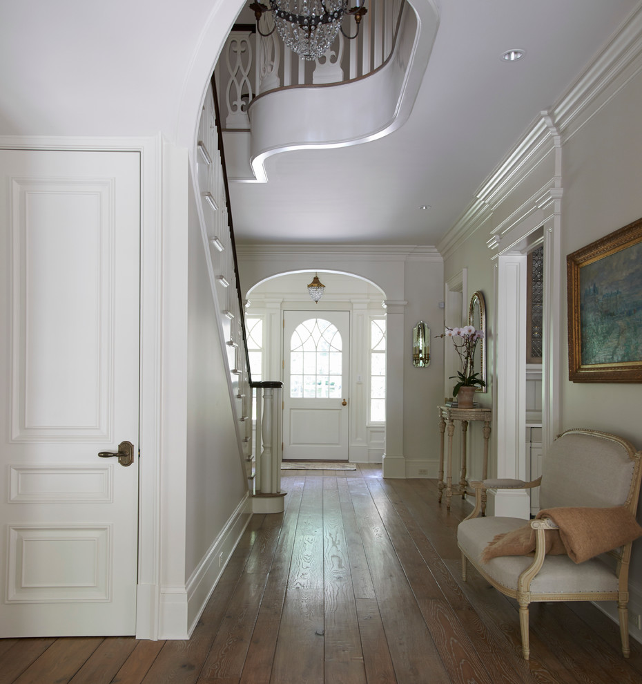 Mid-sized traditional entry hall in New York with white walls, medium hardwood floors, a single front door, a white front door and brown floor.