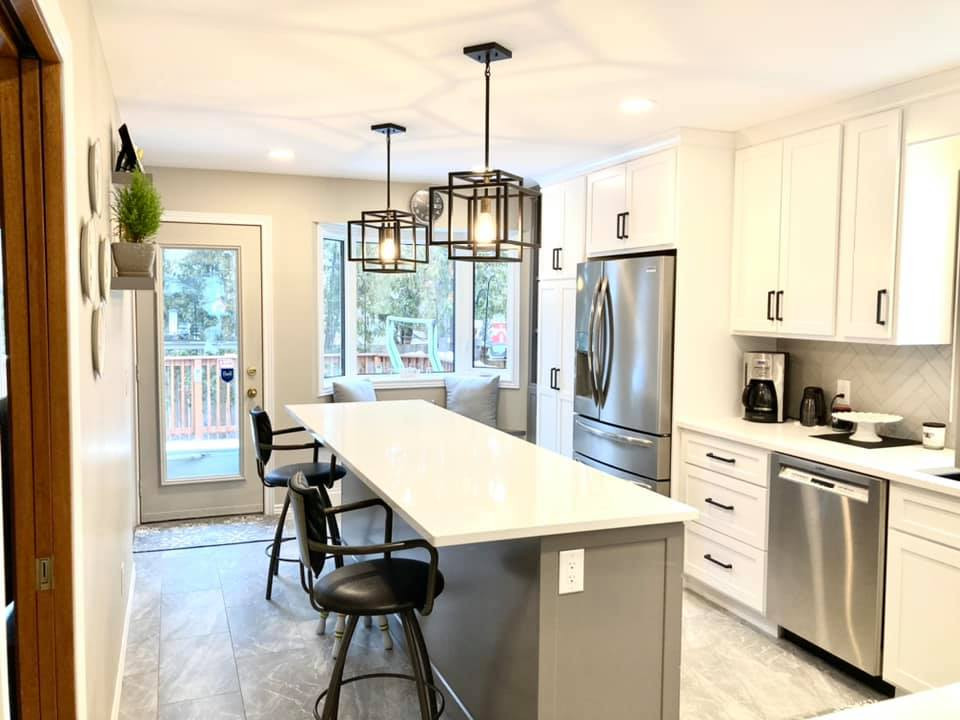 Mid-sized transitional galley ceramic tile and gray floor enclosed kitchen photo with a double-bowl sink, shaker cabinets, white cabinets, quartz countertops, gray backsplash, ceramic backsplash, stainless steel appliances, an island and white countertops