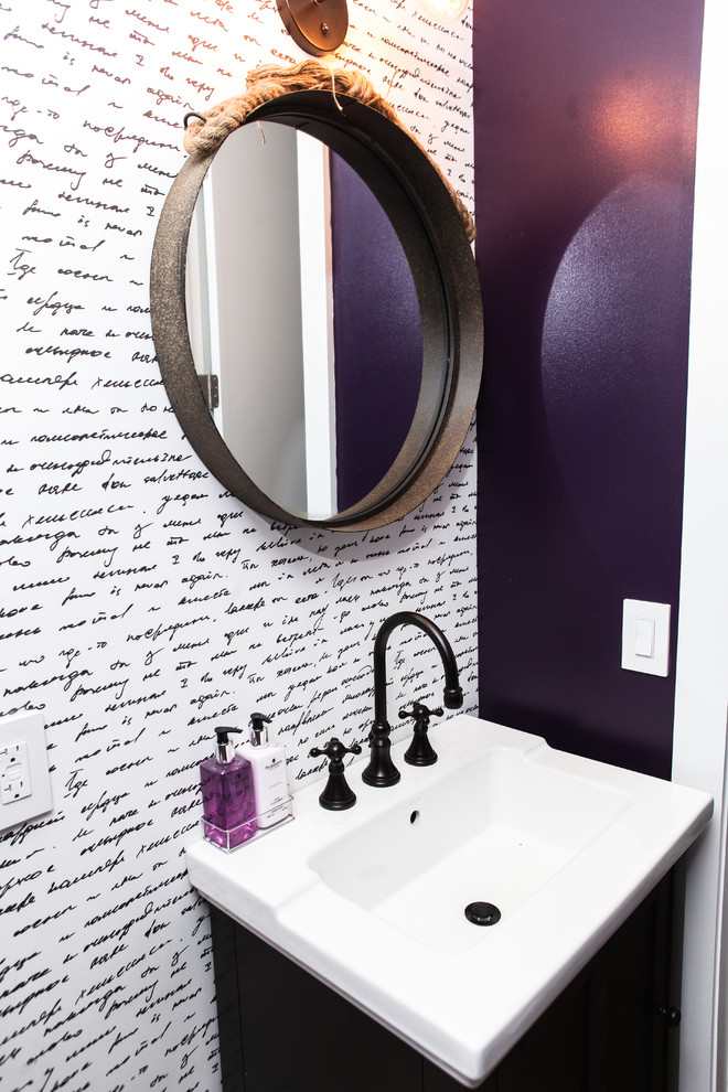 This is an example of a small eclectic powder room in New York with dark wood cabinets, purple walls and an integrated sink.