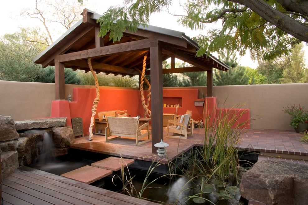 Design ideas for an asian courtyard patio in Albuquerque with a water feature, brick pavers and a pergola.