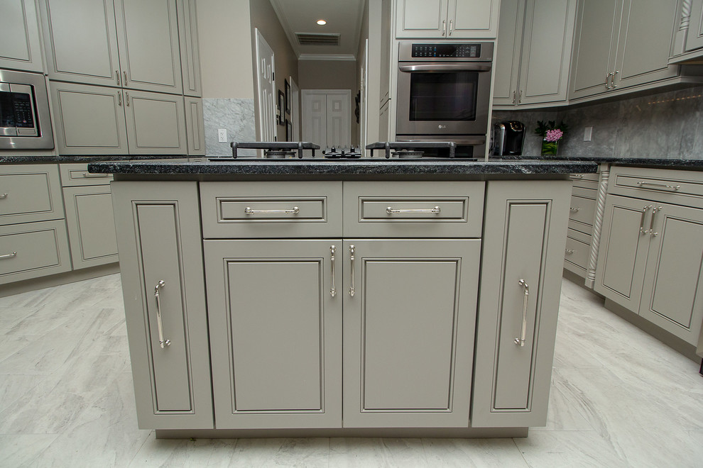 Large transitional l-shaped porcelain tile and white floor eat-in kitchen photo in Houston with a single-bowl sink, beaded inset cabinets, gray cabinets, granite countertops, white backsplash, marble backsplash, stainless steel appliances, two islands and black countertops