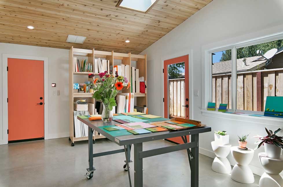 Photo of a mid-sized scandinavian home studio in San Francisco with white walls, concrete floors and grey floor.