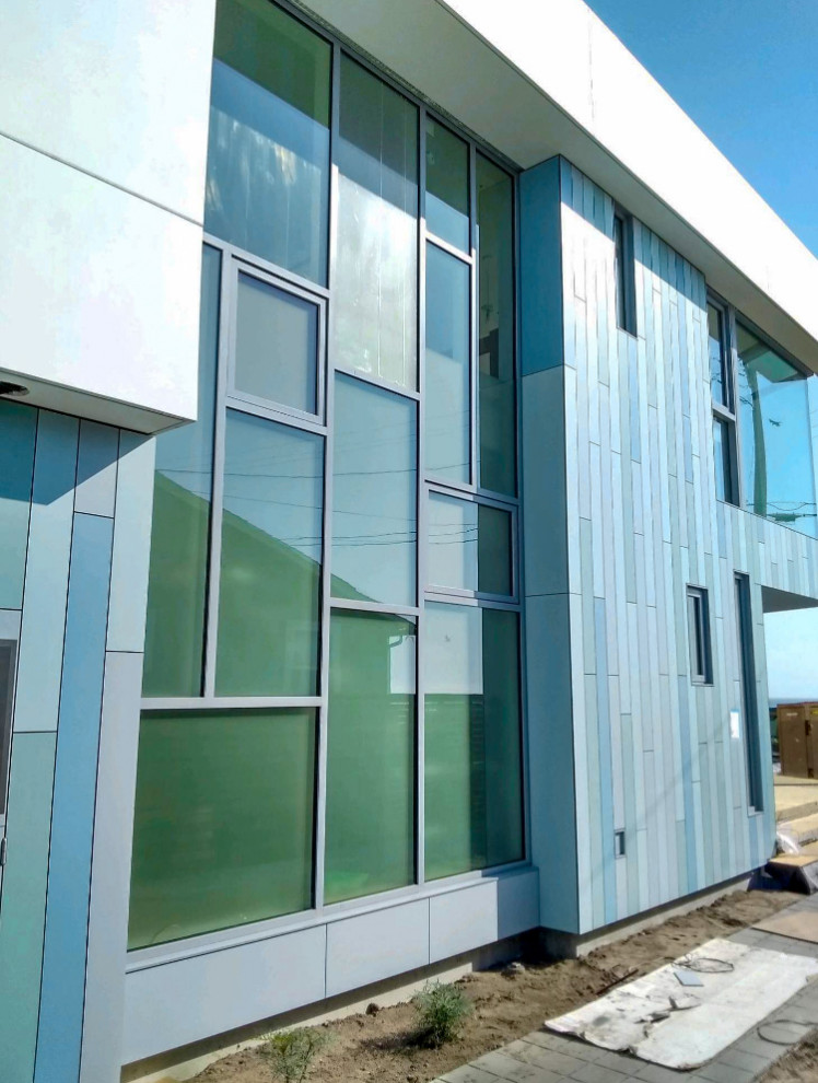 Ispirazione per la villa blu moderna a due piani di medie dimensioni con rivestimento in vetro, copertura in tegole e tetto bianco