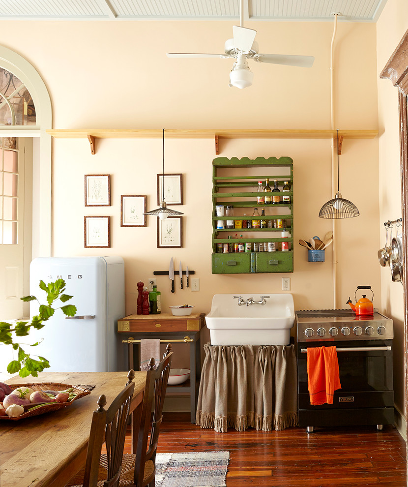 Photo of a small eclectic single-wall eat-in kitchen in New Orleans with a farmhouse sink and dark hardwood floors.