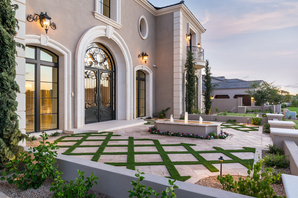 Expansive mediterranean two-storey stucco beige house exterior in Phoenix with a hip roof and a shingle roof.