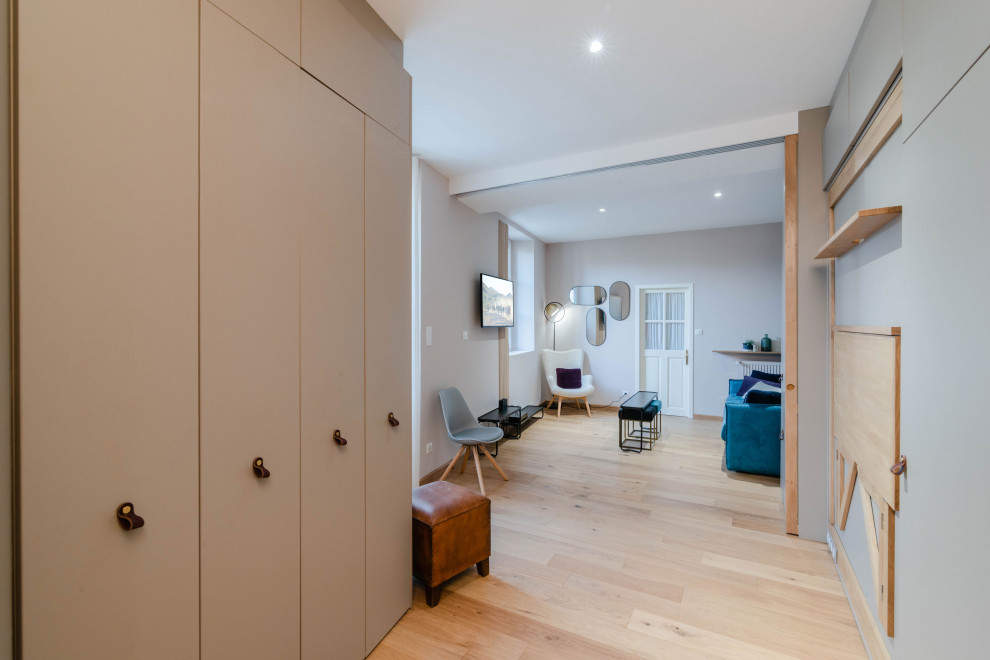 Mittelgroßes Skandinavisches Arbeitszimmer mit beiger Wandfarbe, hellem Holzboden, Einbau-Schreibtisch und Studio in Sonstige