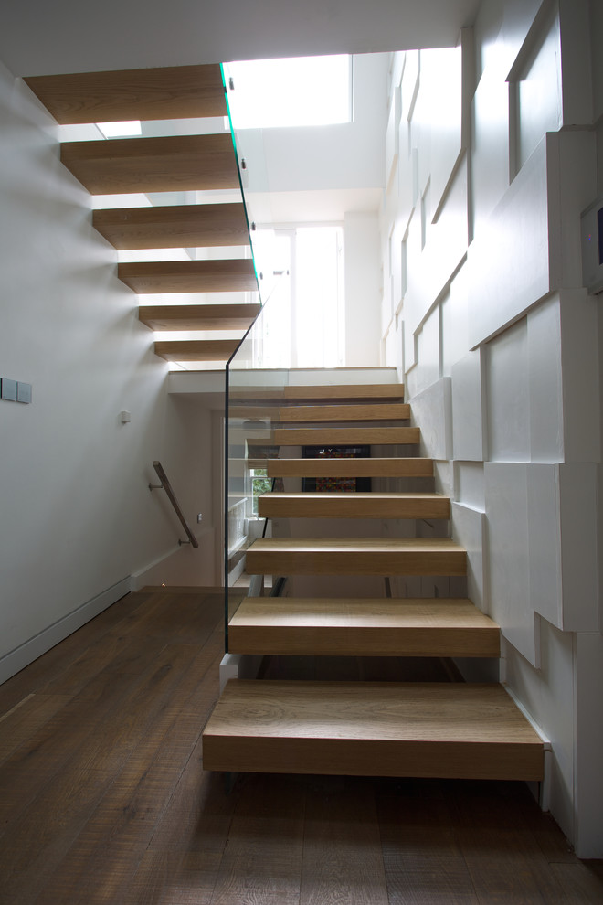 Inspiration for a mid-sized contemporary wood u-shaped staircase in London with open risers.
