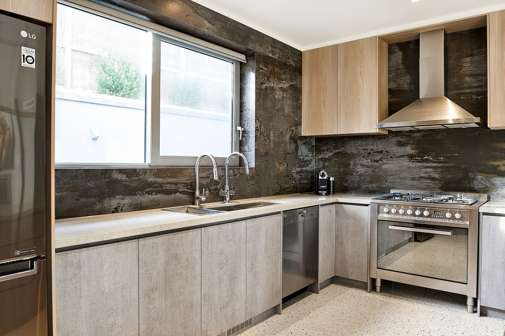 Foto på ett stort funkis grå kök, med en undermonterad diskho, släta luckor, grå skåp, bänkskiva i kvarts, brunt stänkskydd, stänkskydd i keramik, rostfria vitvaror, betonggolv och en köksö