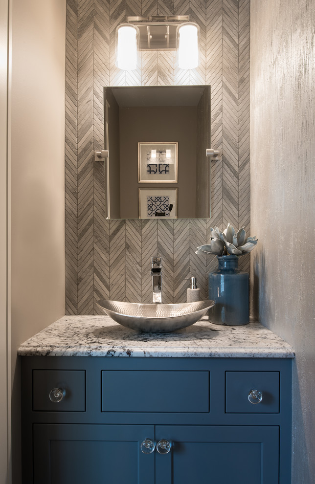Small transitional powder room in Minneapolis with shaker cabinets, blue cabinets, gray tile, marble, grey walls, a vessel sink and granite benchtops.