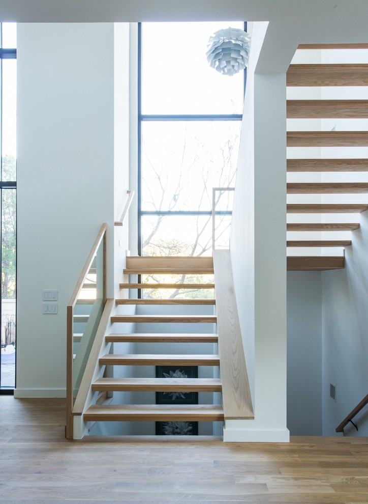 Design ideas for a contemporary wood floating staircase in Dallas with open risers and glass railing.