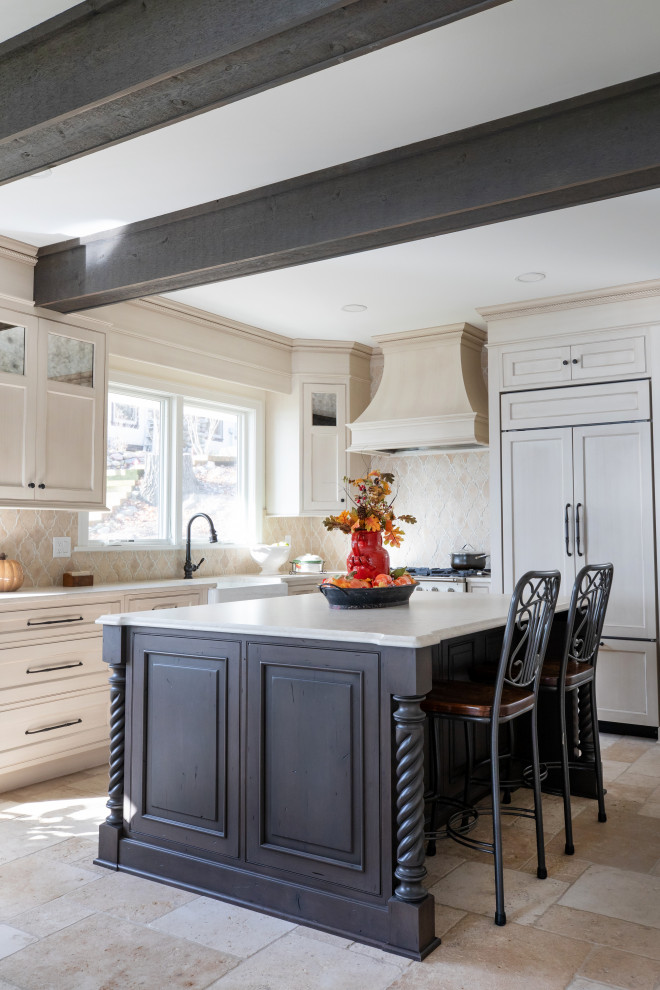 Mid-sized traditional l-shaped eat-in kitchen in Milwaukee with a farmhouse sink, beaded inset cabinets, distressed cabinets, quartz benchtops, beige splashback, limestone splashback, panelled appliances, limestone floors, with island, beige floor, white benchtop and exposed beam.