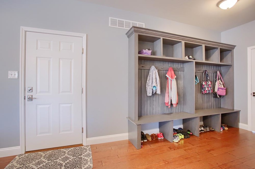 Inspiration for a mid-sized transitional brown floor mudroom remodel with gray walls and a white front door