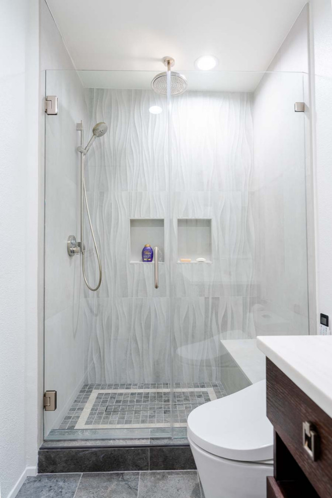 Foto på ett mellanstort funkis vit en-suite badrum, med släta luckor, skåp i slitet trä, en dusch i en alkov, en toalettstol med hel cisternkåpa, grå kakel, cementkakel, vita väggar, betonggolv, ett nedsänkt handfat, marmorbänkskiva, grått golv och dusch med gångjärnsdörr