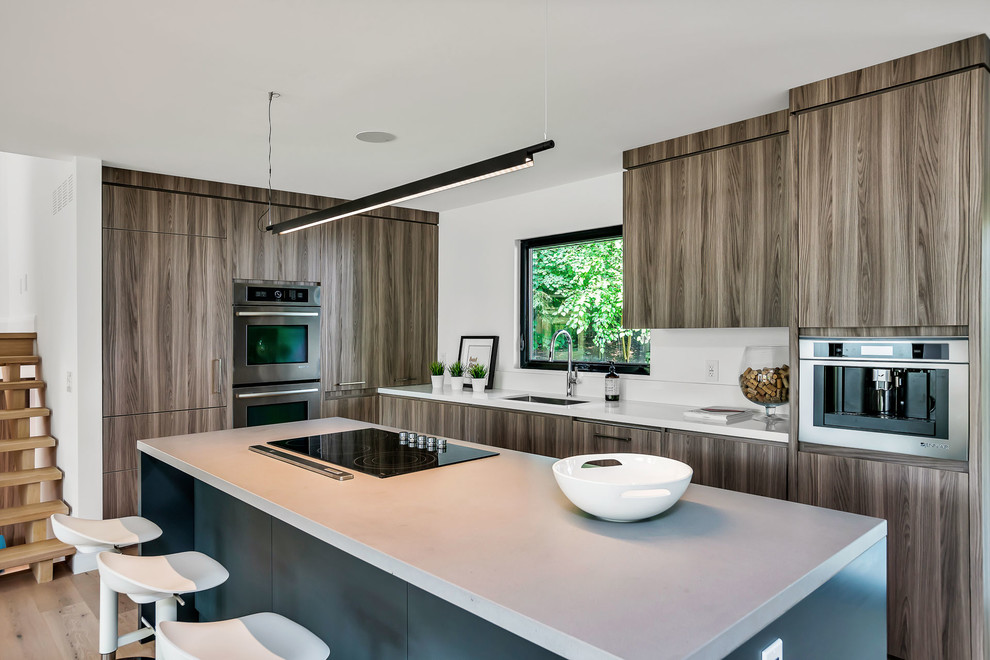 Example of a mid-sized trendy l-shaped light wood floor and beige floor open concept kitchen design in Toronto with an undermount sink, flat-panel cabinets, brown cabinets, stainless steel appliances, an island, quartz countertops and white countertops