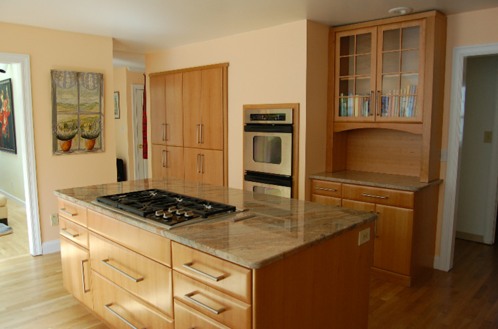 Kitchen - light wood floor kitchen idea with flat-panel cabinets, light wood cabinets, stainless steel appliances and an island