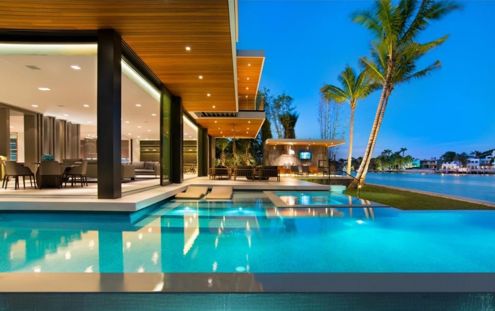 Design ideas for a large modern backyard infinity pool in Miami with a hot tub.