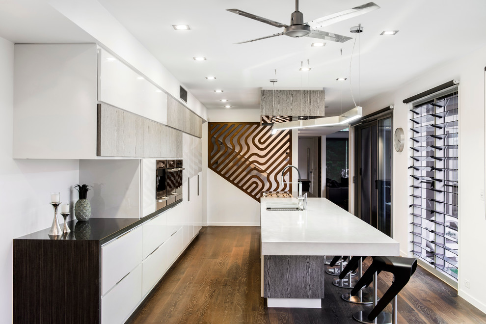 Inspiration for a mid-sized contemporary galley eat-in kitchen in Brisbane with an undermount sink, flat-panel cabinets, stainless steel appliances, dark hardwood floors and with island.