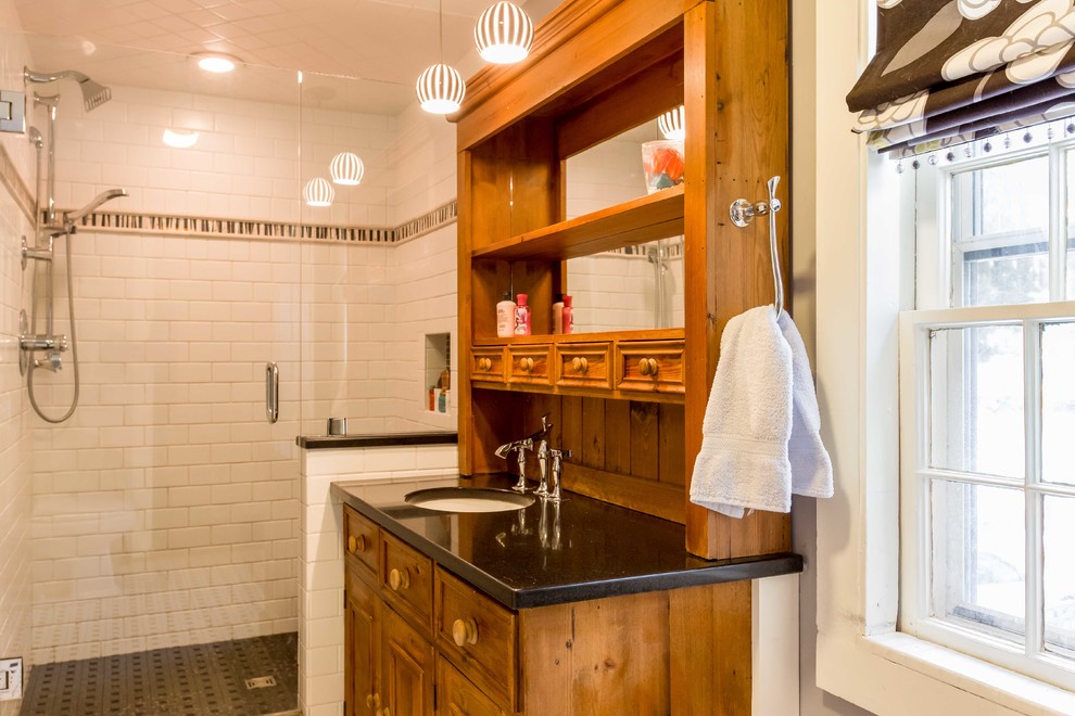 Inspiration for a mid-sized country bathroom in Other with an undermount sink, furniture-like cabinets, medium wood cabinets, granite benchtops, a two-piece toilet, white tile, subway tile, grey walls, porcelain floors and an alcove shower.