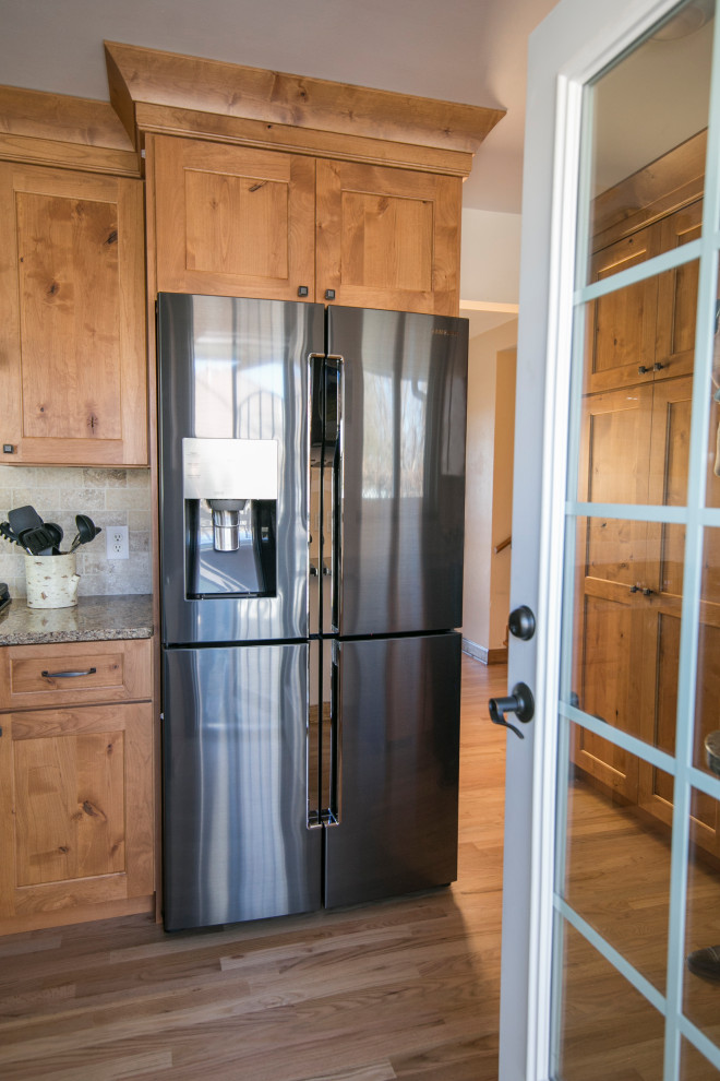 Inspiration for a mid-sized rustic galley medium tone wood floor and brown floor eat-in kitchen remodel in Denver with an undermount sink, shaker cabinets, medium tone wood cabinets, quartz countertops, gray backsplash, stone tile backsplash, black appliances, no island and brown countertops