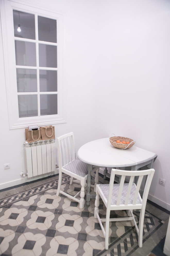 Diseño de comedor de cocina tradicional renovado pequeño sin chimenea con paredes blancas y suelo de baldosas de cerámica