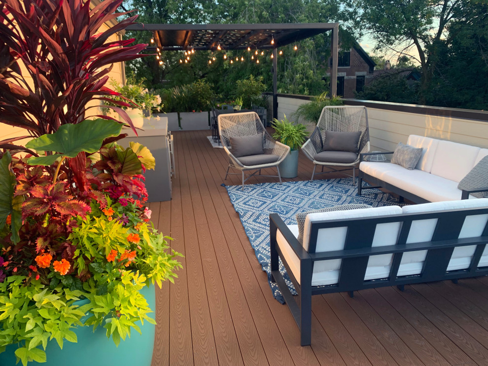 This is an example of a small modern roof rooftop metal railing terrace in Chicago with an outdoor kitchen and a pergola.