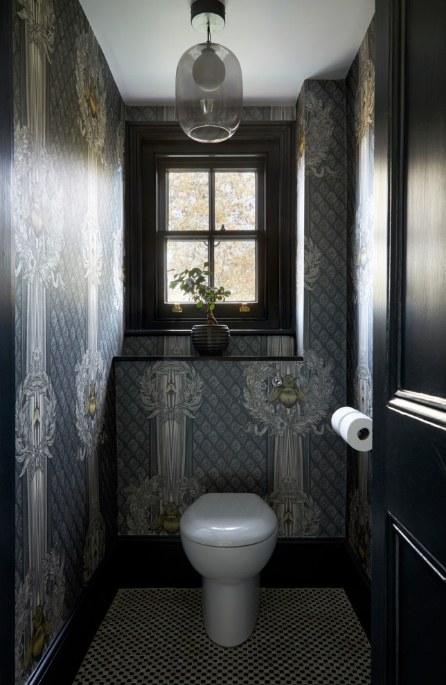 Small traditional powder room in Surrey with ceramic floors, black floor and wallpaper.