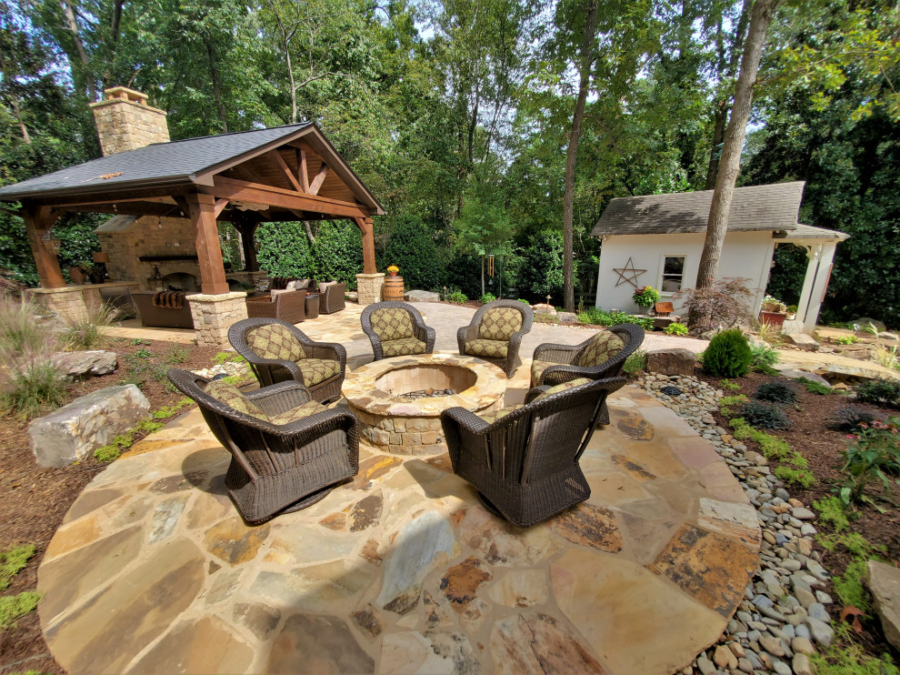 Ejemplo de patio rústico de tamaño medio en patio trasero con brasero, adoquines de piedra natural y cenador