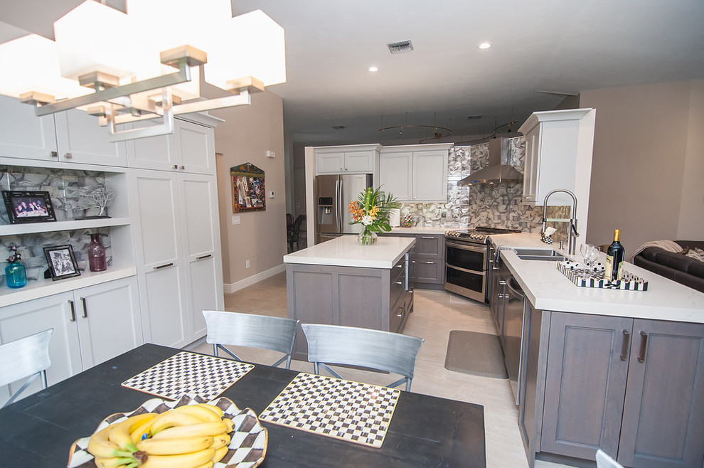 Example of a mid-sized transitional u-shaped porcelain tile and beige floor eat-in kitchen design in Miami with an undermount sink, shaker cabinets, gray cabinets, quartz countertops, gray backsplash, glass tile backsplash, stainless steel appliances, an island and white countertops