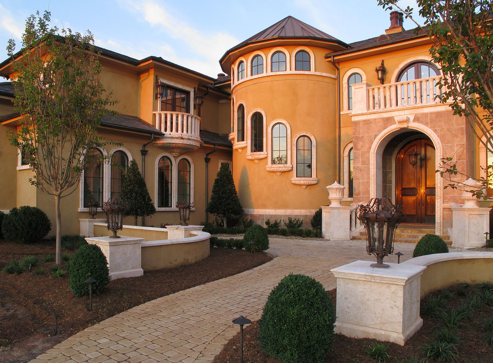 Photo of an expansive mediterranean two-storey exterior in Other with stone veneer.