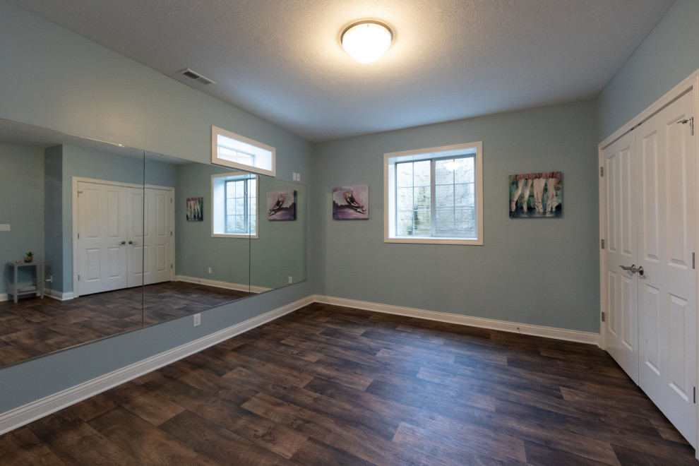 This is an example of a mid-sized contemporary teen room for girls in Other with blue walls, vinyl floors and brown floor.