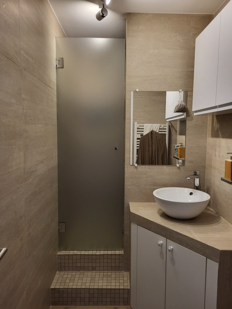 Inspiration for a small modern 3/4 bathroom in Marseille with beaded inset cabinets, white cabinets, a wall-mount toilet, beige tile, beige walls, dark hardwood floors, a drop-in sink, tile benchtops, a hinged shower door, a single vanity and a built-in vanity.