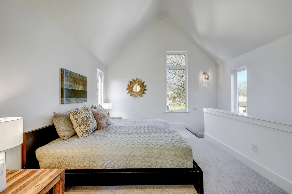 This is an example of a transitional loft-style bedroom in Austin with white walls, carpet, no fireplace and grey floor.