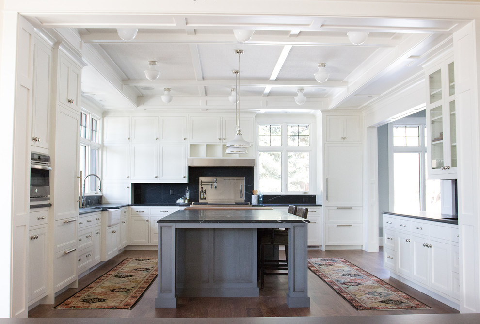 Example of a large transitional u-shaped dark wood floor eat-in kitchen design in Denver with a farmhouse sink, recessed-panel cabinets, white cabinets, wood countertops, black backsplash, stone slab backsplash, stainless steel appliances and an island