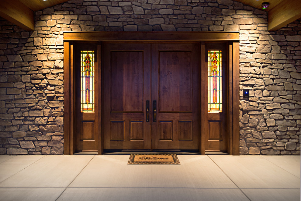 Photo of an expansive arts and crafts front door in Denver with concrete floors, a double front door and a medium wood front door.