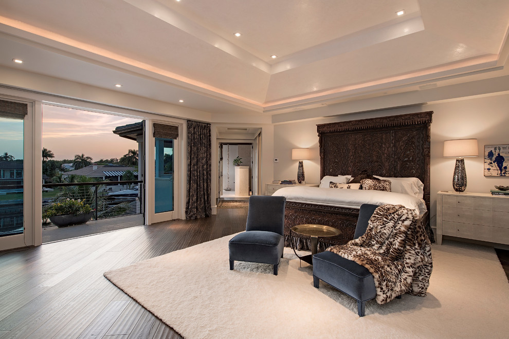 This is an example of a large transitional master bedroom in Tampa with white walls and terra-cotta floors.